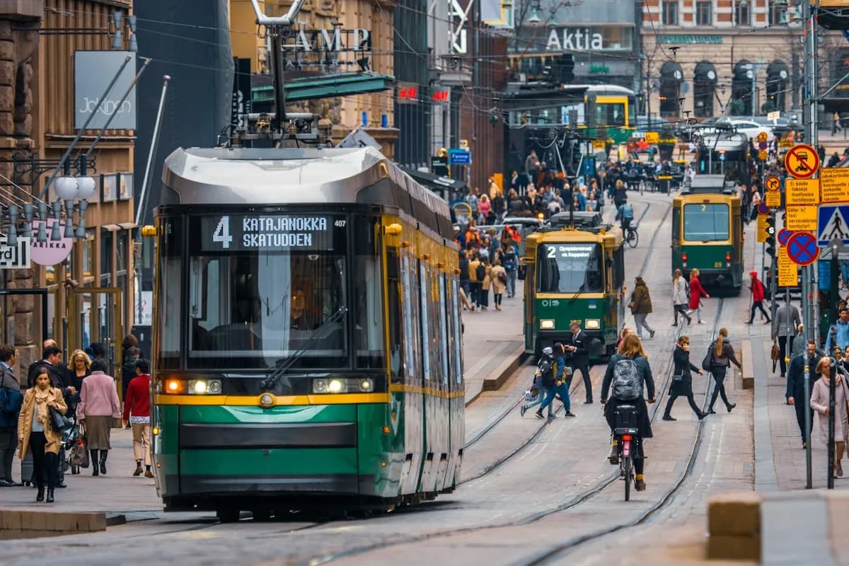 Green and yellow tram among pedestrians on Aleksanterinkatu in Helsinki