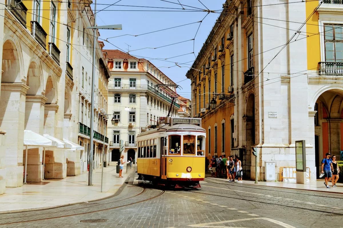 Yellow Lisbon tram traveling between historic buildings