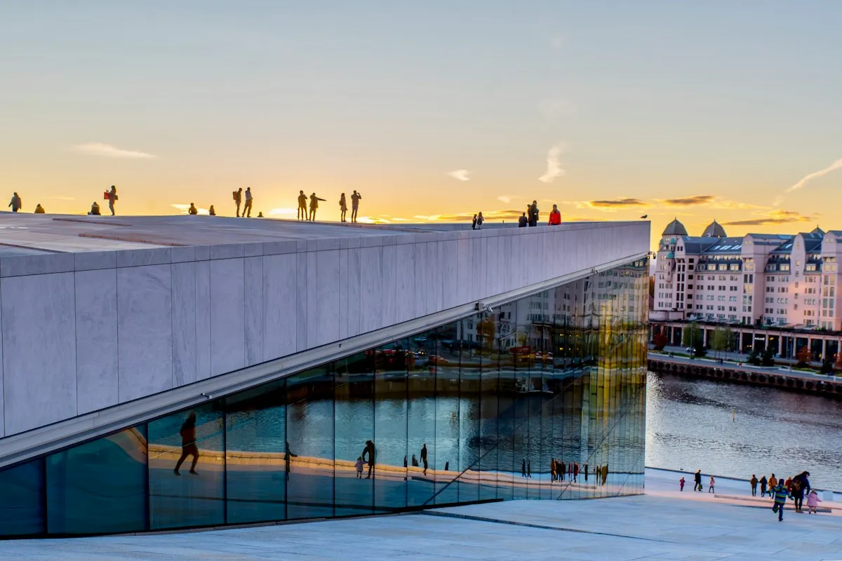 Visitors walking on the sloping white roof of Oslo Opera House