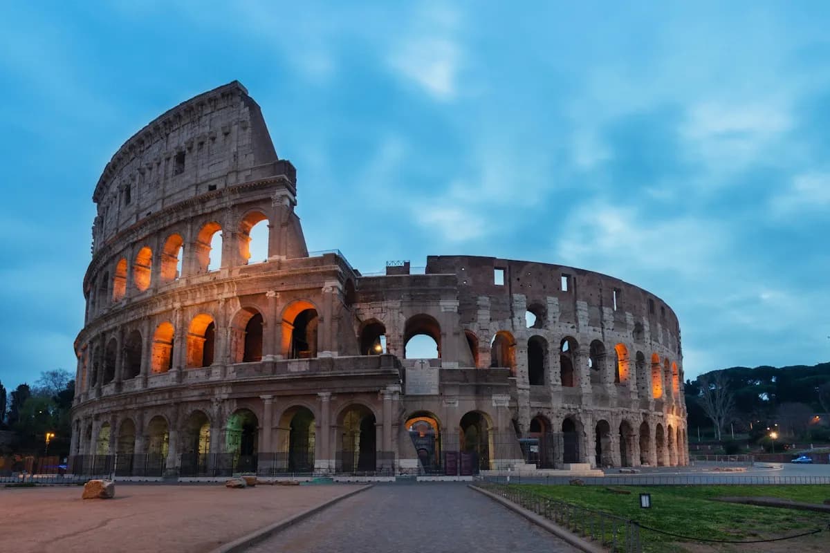 Illuminated arches of the Colosseum in Rome at daybreak