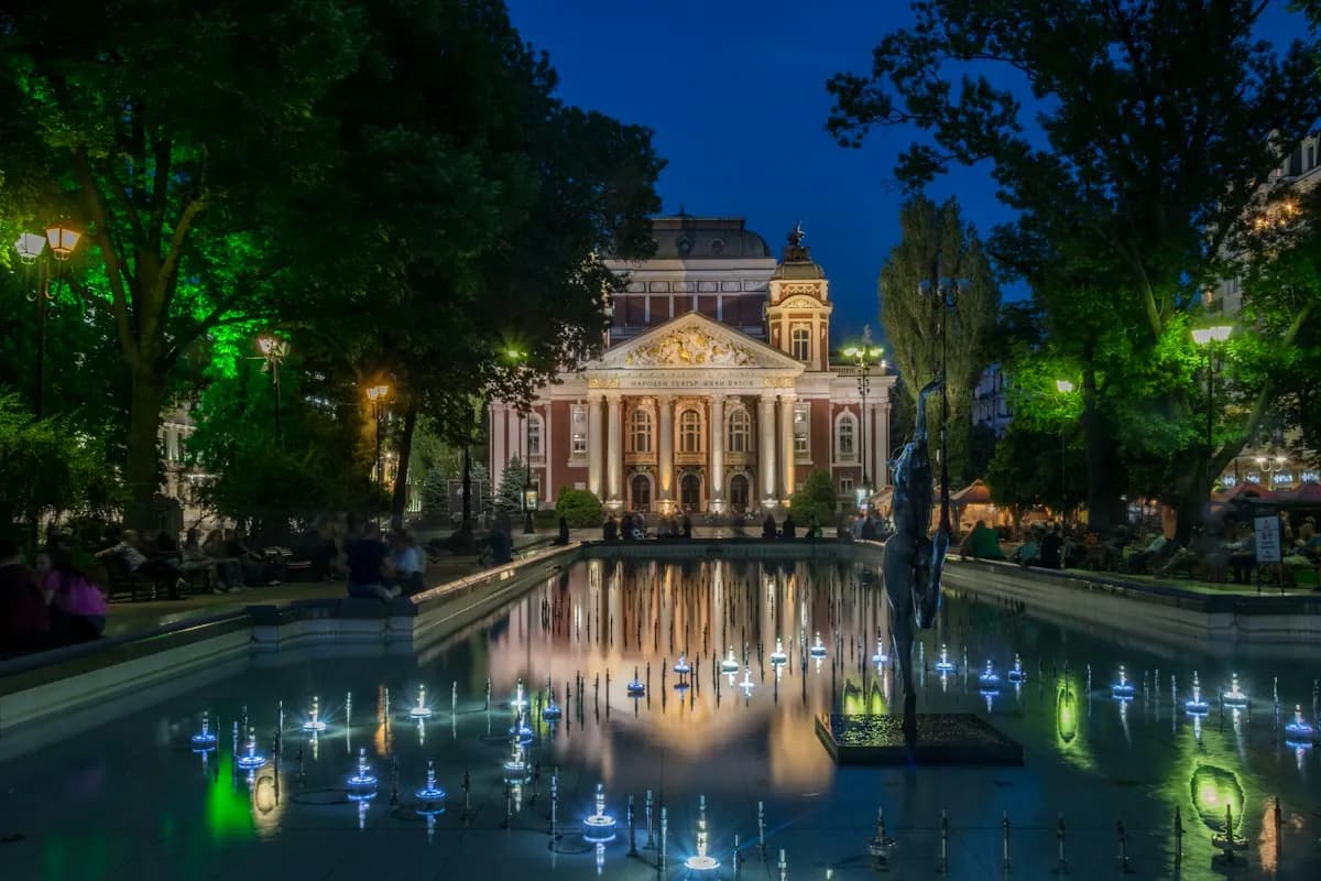 Illuminated theater and fountains in Sofia’s city garden at night